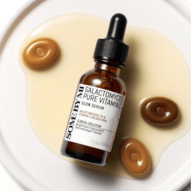 SOME BY MI Galactomyces Pure Vitamin C Glow Serum 30ml de la marque SOME BY MI, gouttes dorées sur fond crème.