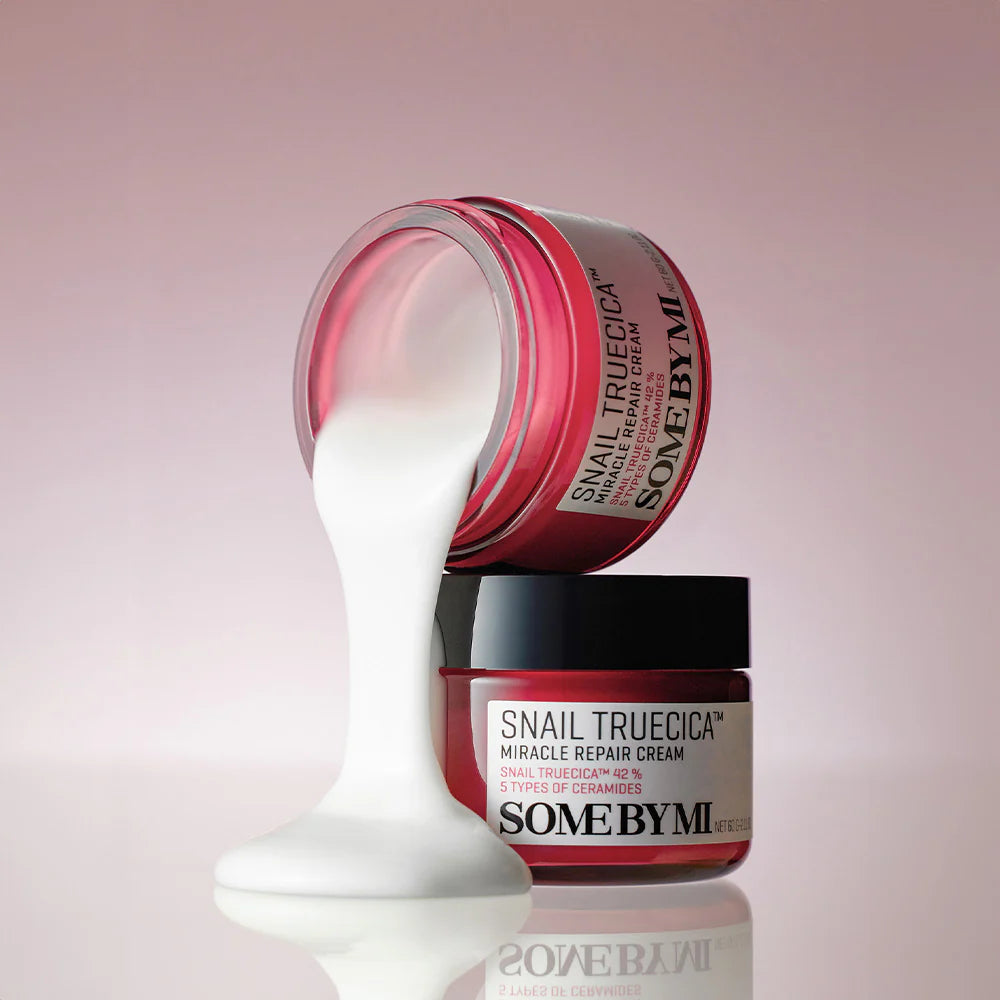 SOME BY MI Snail Truecica Miracle Repair Cream 60g, crème SOME BY MI sur fond rose, pot ouvert avec texture blanche.