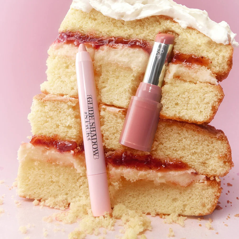 TIP TOE Glide Shadow Stick de la marque Tip Toe, sur fond rose pastel avec cupcakes, image produit maquillage.