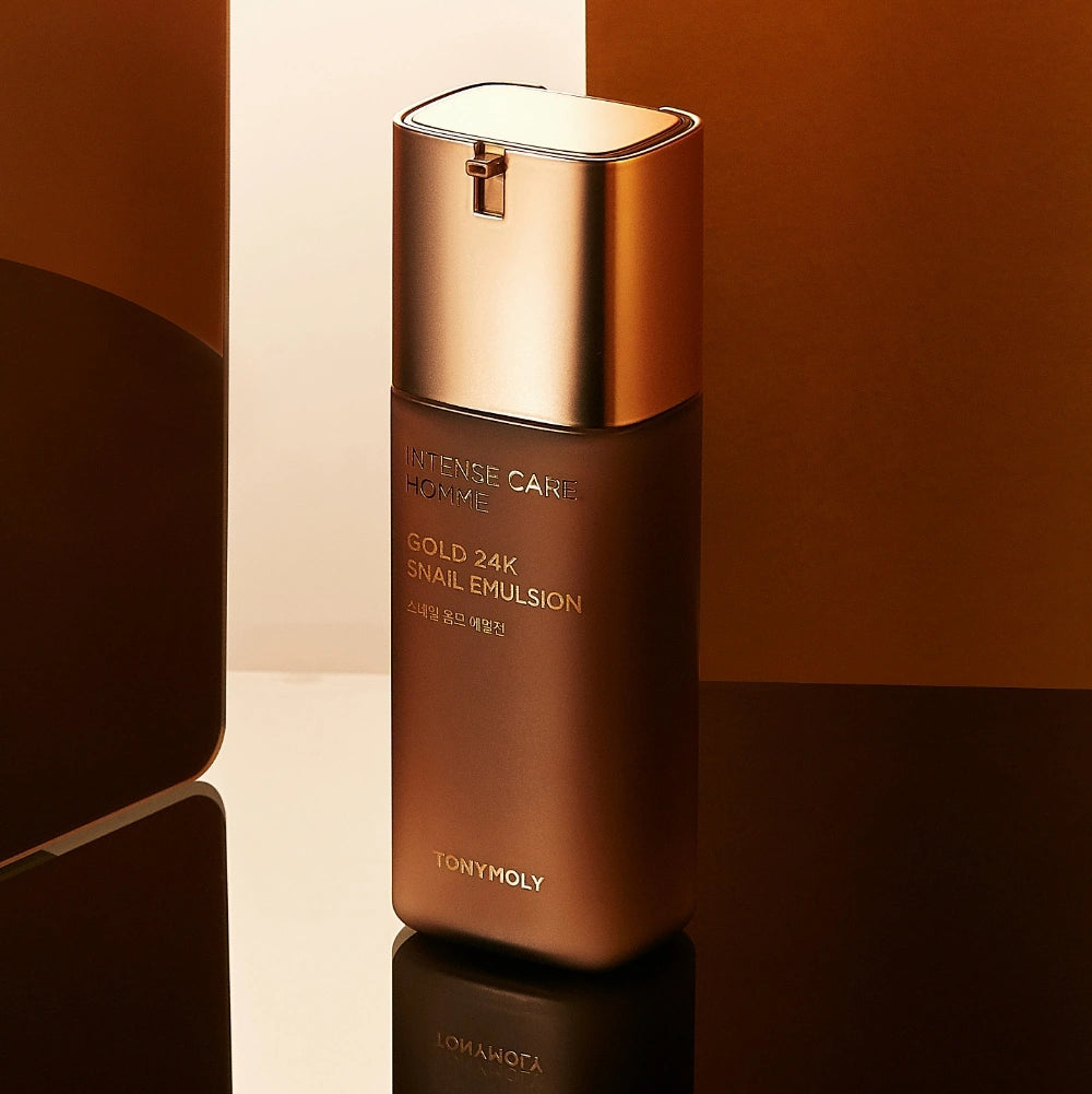 TONYMOLY Intense Care Gold 24K Snail Homme Emulsion 130ml, bouteille dorée sur fond beige et noir.