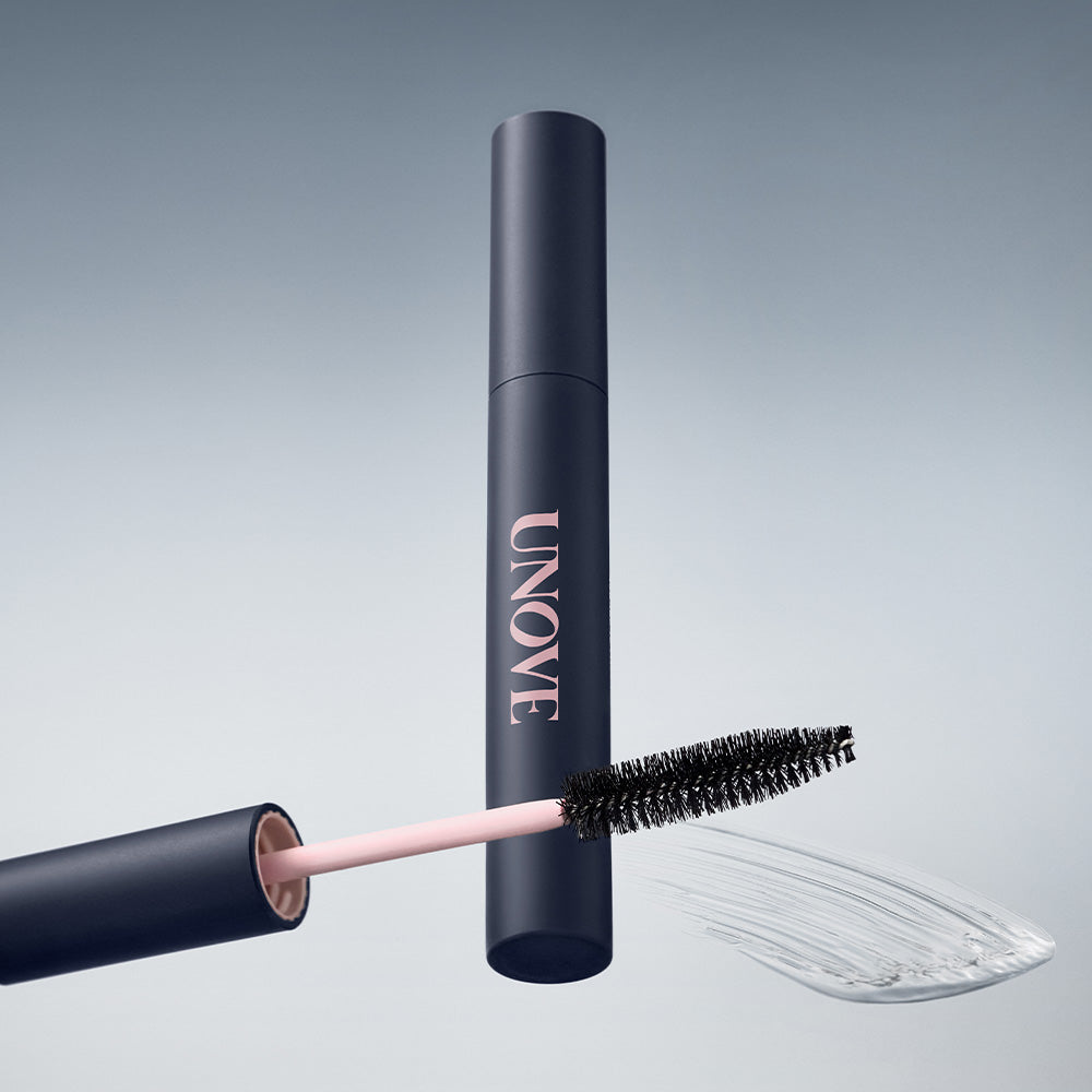 UNOVE Frizz Calming Slick Hair Finishing Stick 10ml de la marque UNOVE, stick coiffant noir et rose, fond clair.