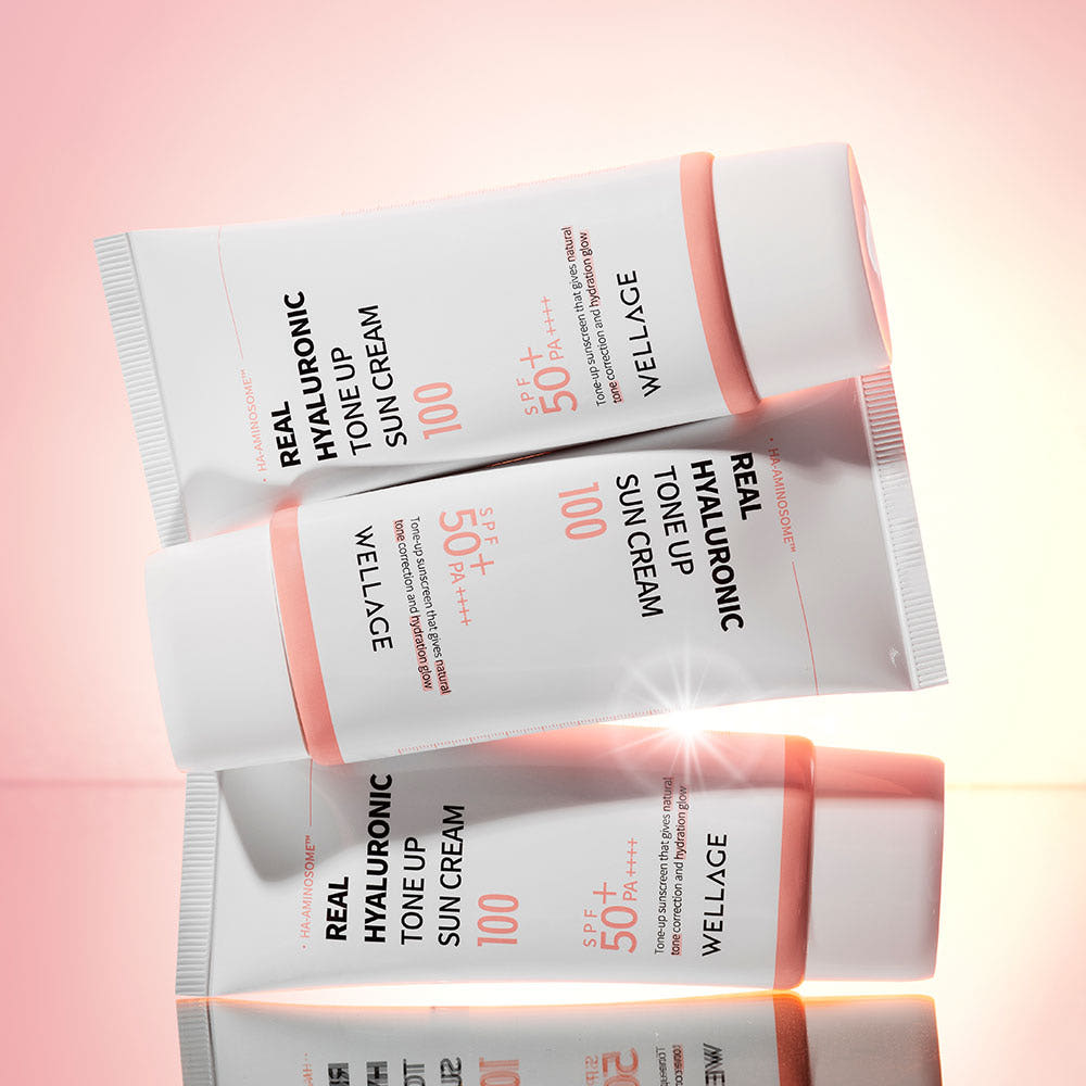 WELLAGE Real Hyaluronic Tone-Up Sunscreen 50ml, tube blanc et rose sur fond rose, détail cosmétique produit