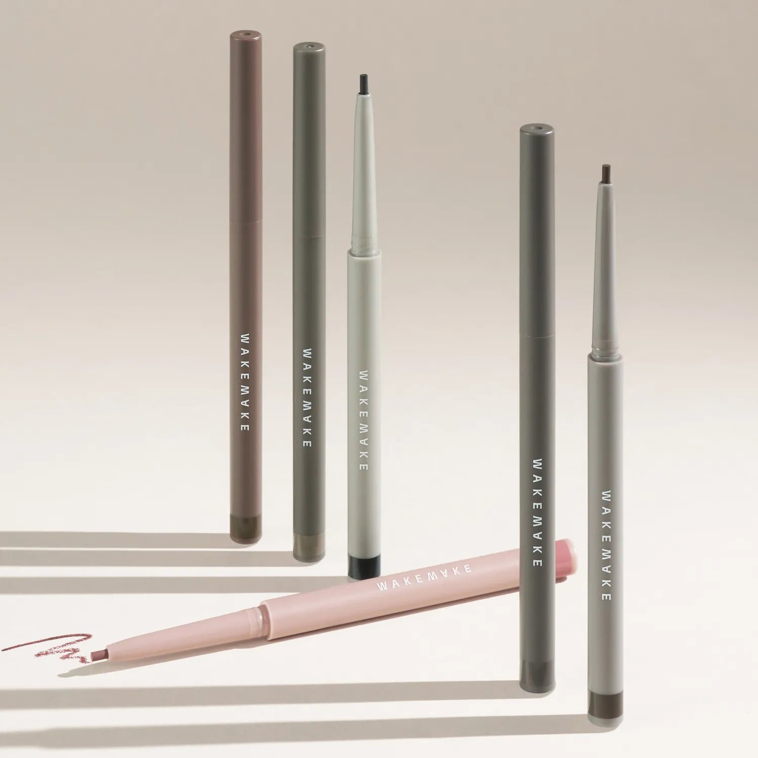WAKEMAKE Real Ash Pencil Eyeliner : crayons eyeliner de la marque sur fond beige, plusieurs teintes en vue.