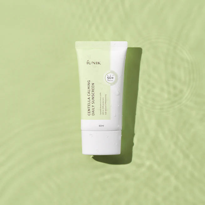 iUNIK Centella Calming Daily Sunscreen 60ml, tube de sunscreen iUNIK sur fond vert apaisant, en contexte skincare.