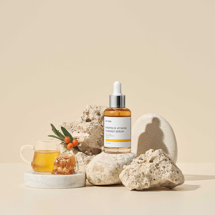 iUNIK Propolis Vitamin Synergy Serum 50ml avec ingrédients naturels et vitamine C, présenté sur un fond beige élégant.