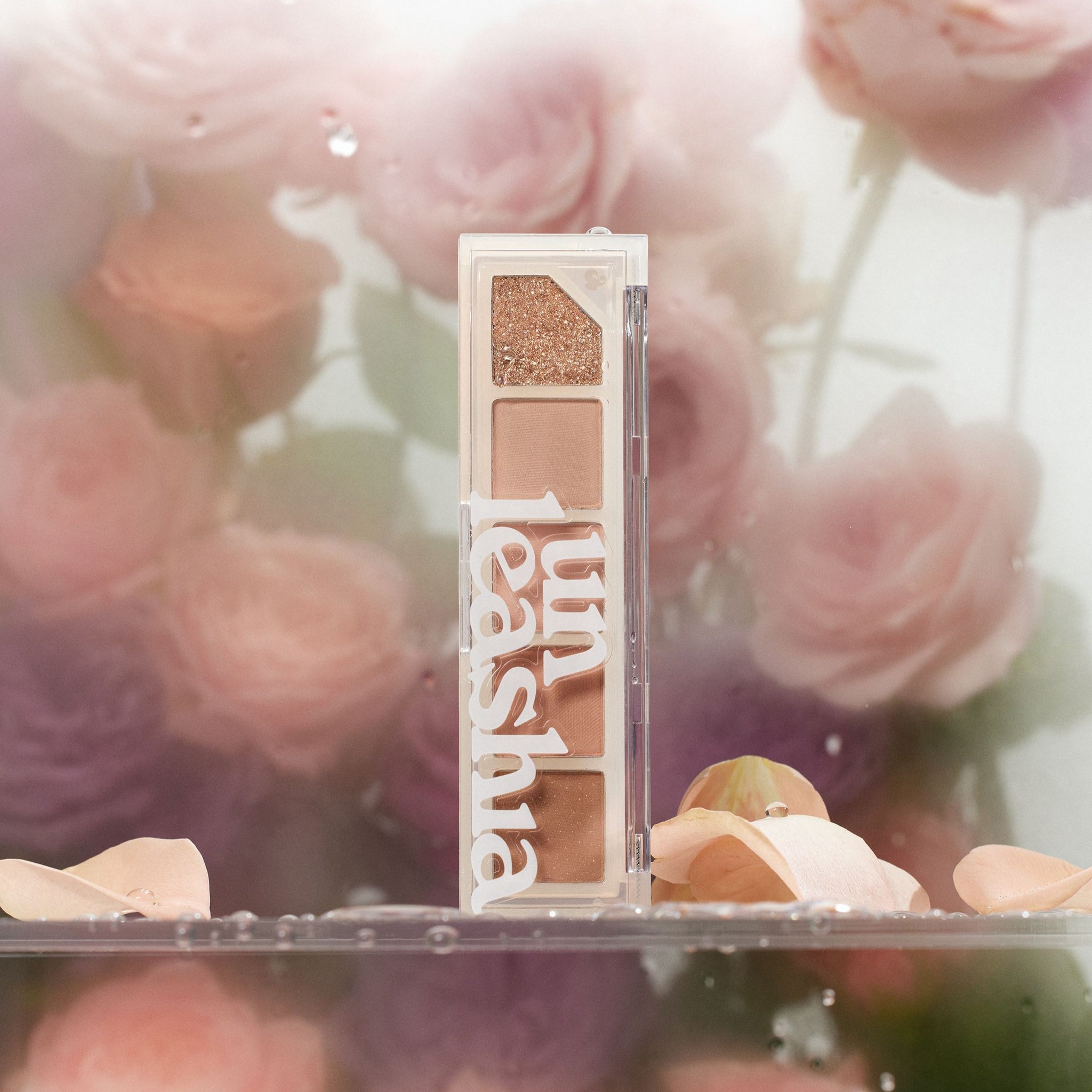UNLEASHIA Mood Shower Eye Palette, marque UNLEASHIA, palette yeux ouverte sur fond floral rose et paillettes.