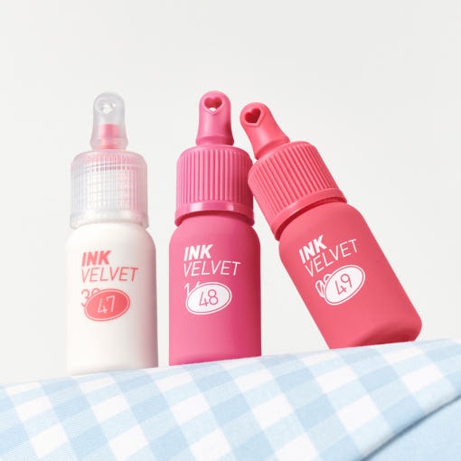 PERIPERA Ink The Velvet : flacons roses sur tissu bleu, visuel produit en studio, marque PERIPERA