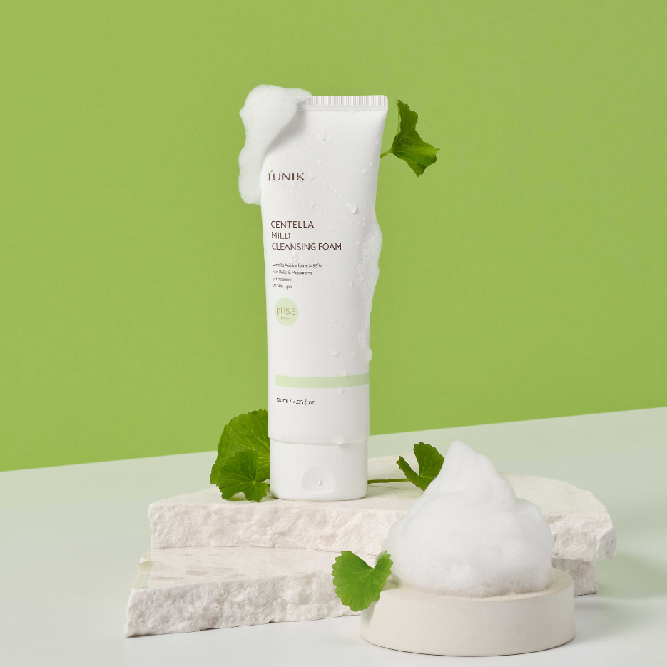 iUNIK Centella Mild Cleansing Foam 120ml de la marque iUNIK, tube sur fond vert, feuilles et mousse blanche.