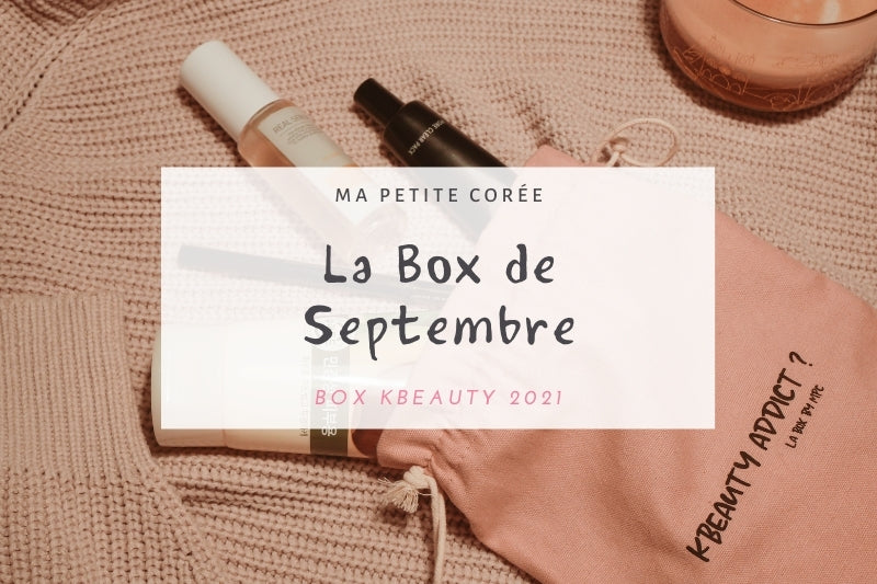 Boîte KBeauty Box Septembre 2021 avec produits de soin sur un pull rose et un pochon rose