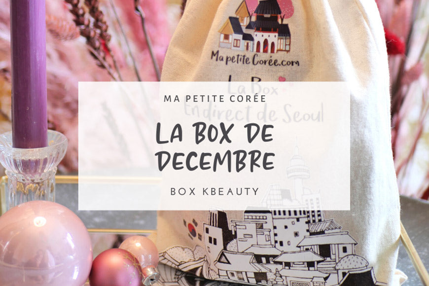 Sac en tissu avec design, à côté de bougies décoratives, représentant la BOX KBEAUTY : LA BOX DE DECEMBRE.