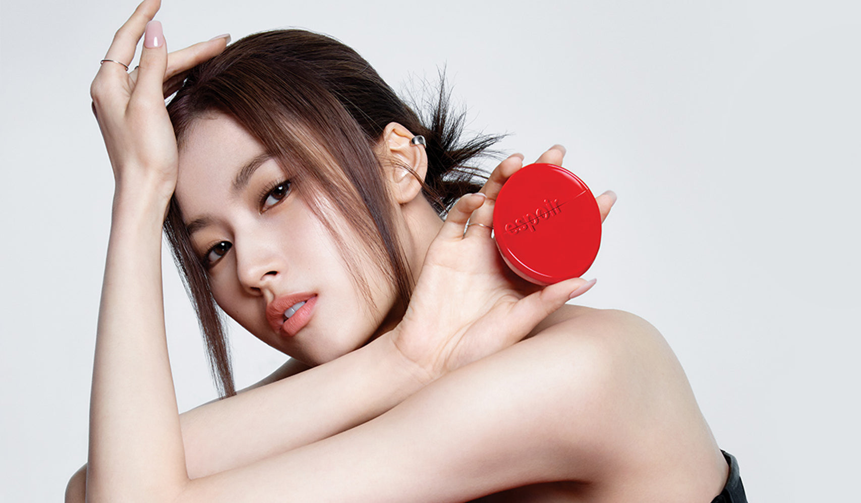 Femme tenant un produit ESPOIR illustrant "ESPOIR : Le Pouvoir du Maquillage pour Révéler Votre Confiance".