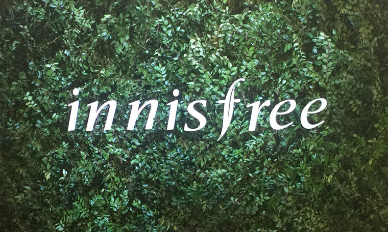Logo Innisfree sur fond de feuillage vert - Pourquoi Innisfree est une marque de soins de la peau à ne pas manquer ?