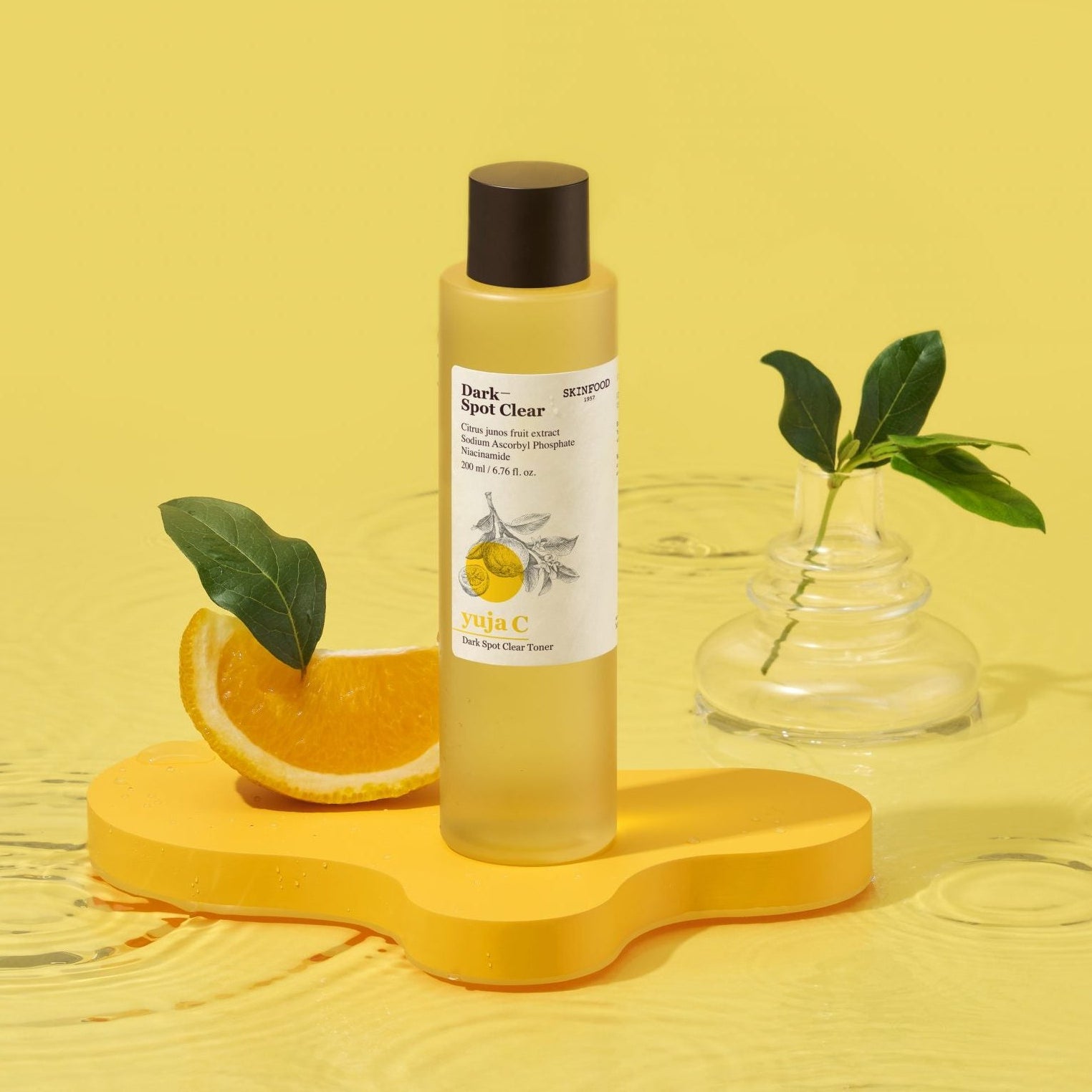 SKINFOOD Yuja C Dark Spot Clear Toner 200ml de SKINFOOD, flacon jaune sur fond jaune, agrumes et feuilles en contexte beauté.