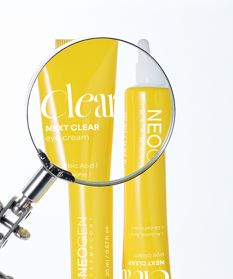 NEOGEN Next Clear Eye Cream 20ml en tube jaune avec loupe pour amélioration de la peau autour des yeux