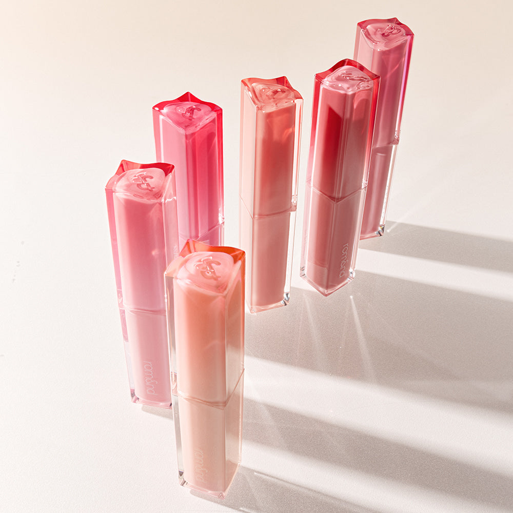 ROMAND Sheer Tinted Stick, baume teinté transparent de la marque ROMAND, sur fond clair avec plusieurs sticks roses.