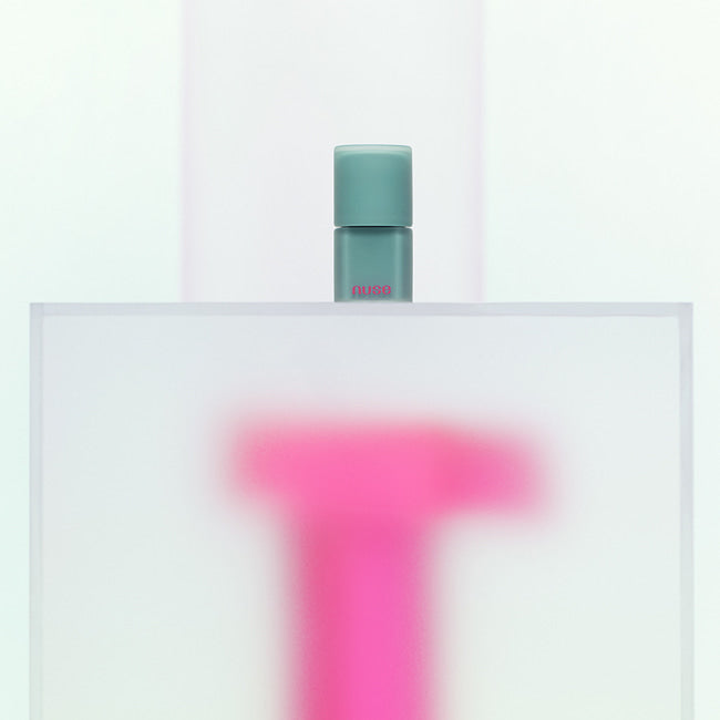 NUSE Mousse Liptual de la marque NUSE, flacon mousse vert sur fond blanc minimaliste, contexte beauté.
