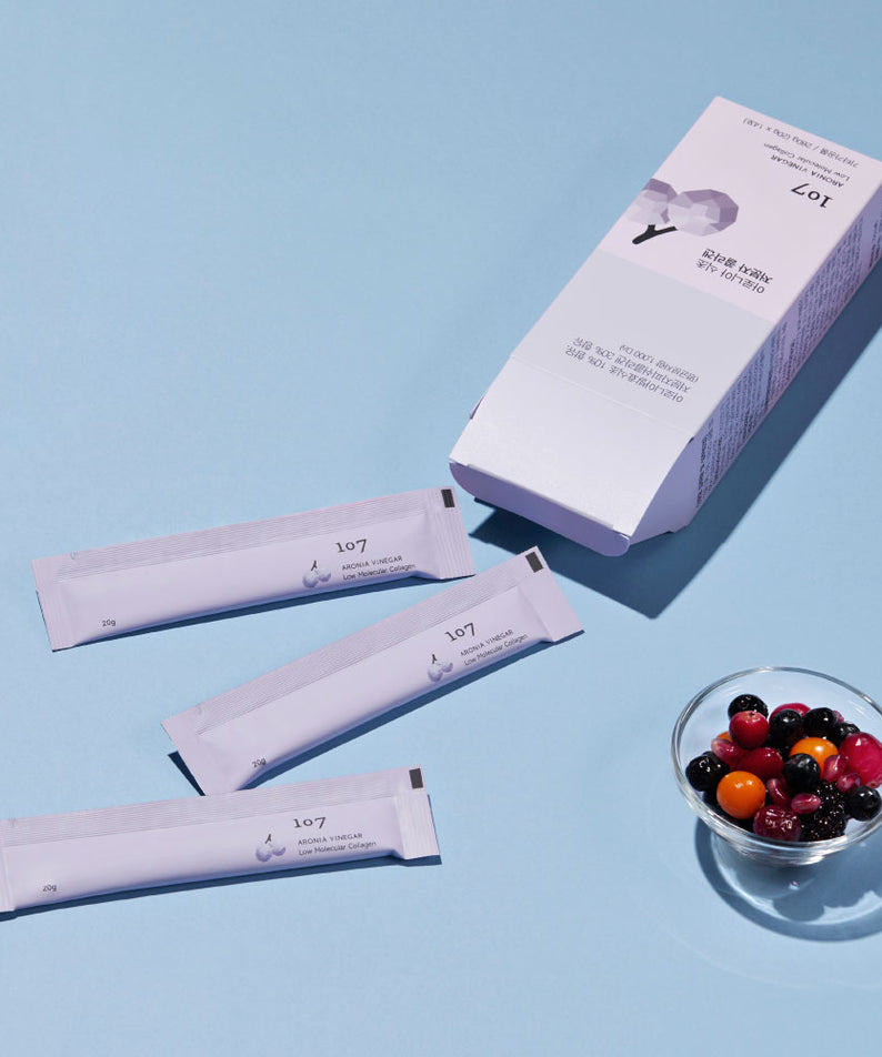 107 Aronia Vinegar Low Molecular Collagen 20g x 14 Packets, compléments beauté en sachets, avec un bol de baies, sur fond bleu.