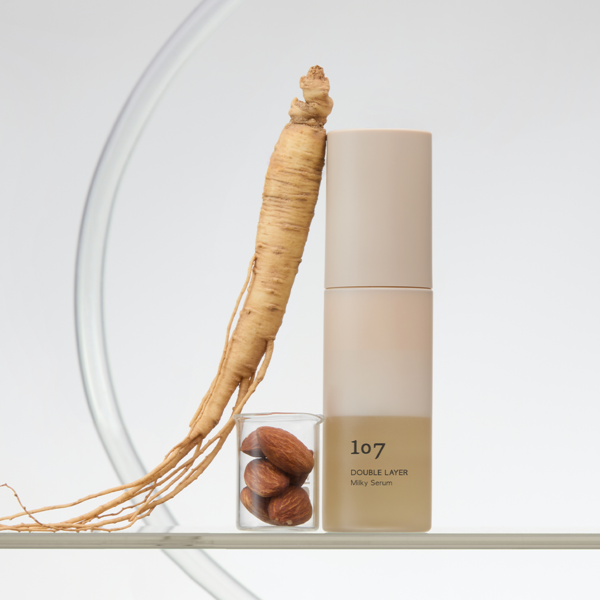 107 Double Layer Milky Serum 50ml de la marque 107, flacon crème avec racine à côté, fond blanc lumineux