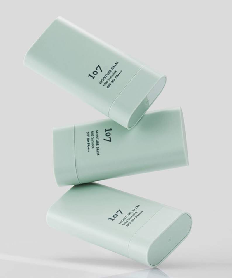 Trois bâtons de 107 Moisture Balm Mild Sun Stick SPF50+PA++++ sur fond blanc