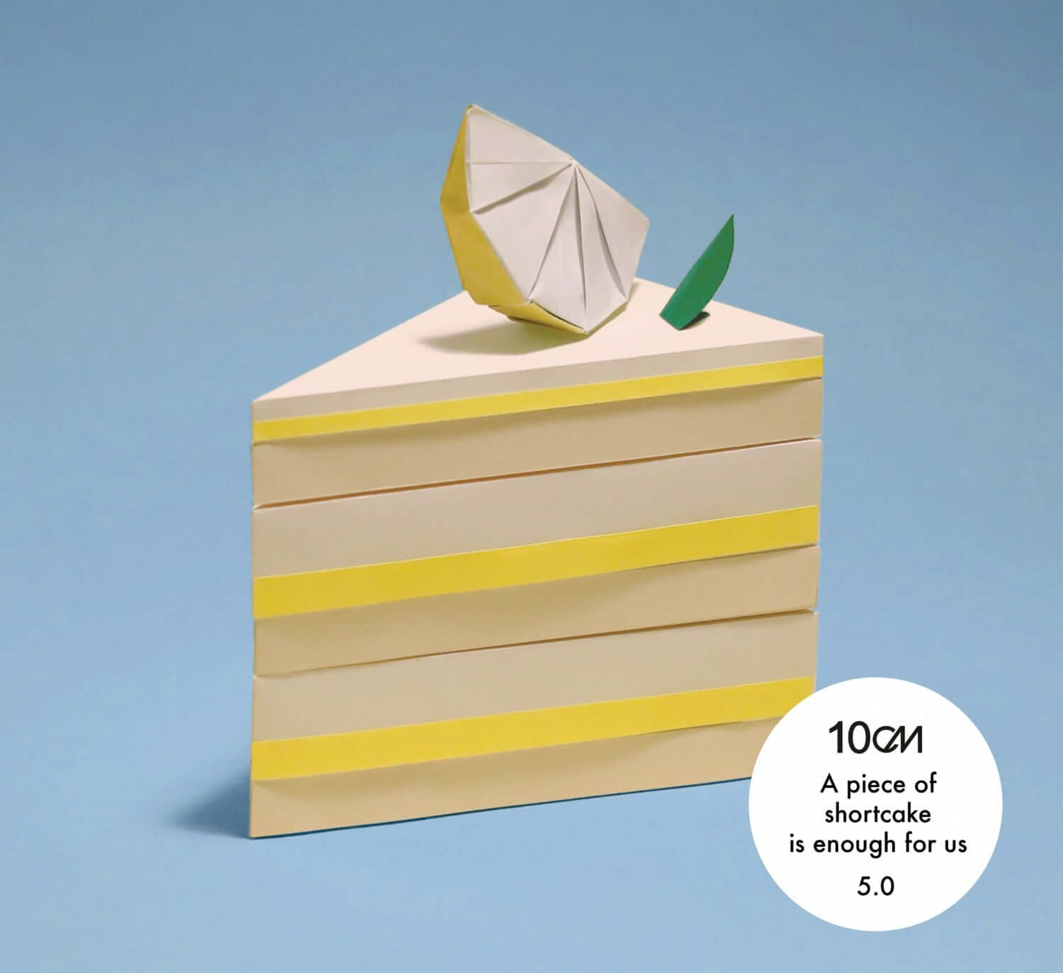 10CM - 5th Album [5.0] - Album Kpop de 10CM, album stylisé sur livre jaune et cube géométrique, fond bleu.