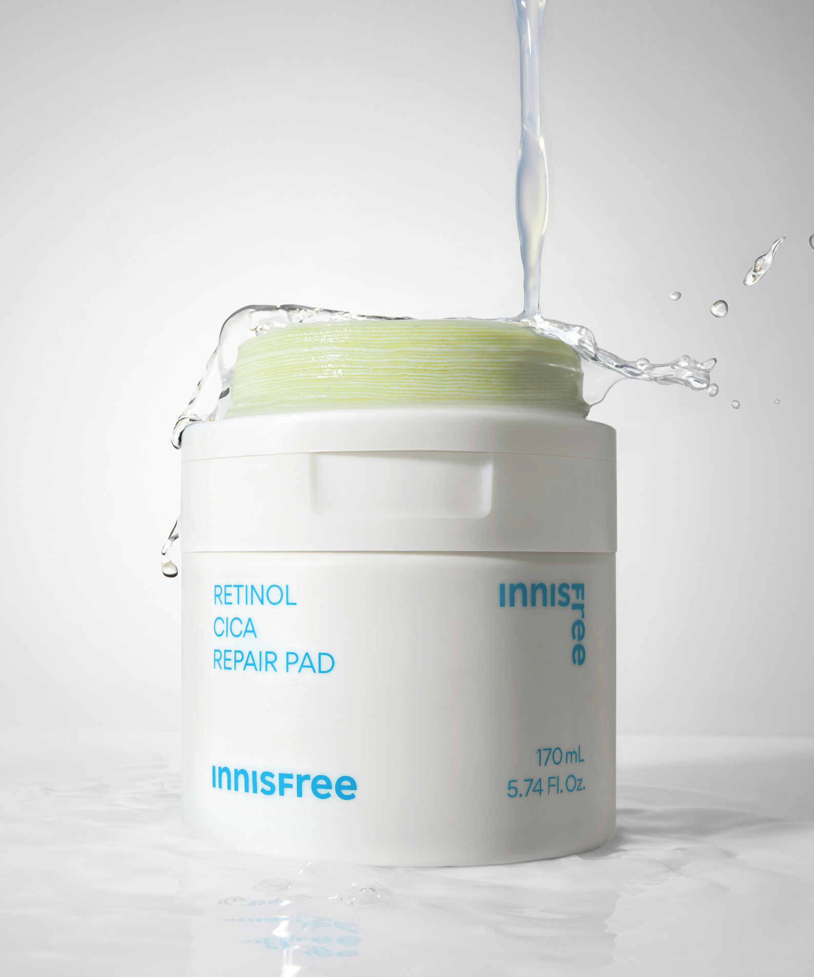 INNISFREE Retinol Cica Repair Pad 60p 170ml : pot blanc avec texte, éclaboussures d’eau, fond studio, beauté skincare