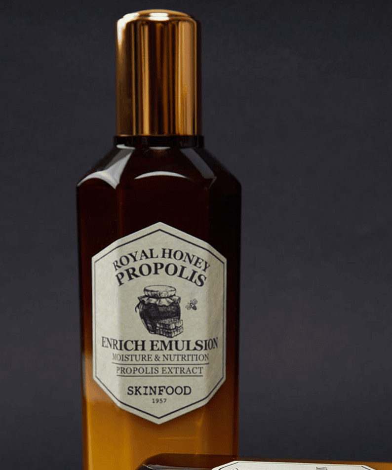 SKINFOOD Royal Honey Propolis Enrich Emulsion 160ml, flacon doré sur fond noir, étiquette Royal Honey Propolis visible.