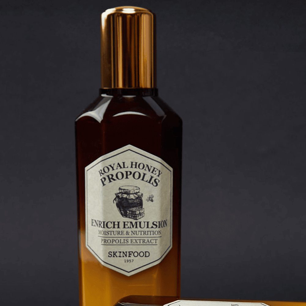 SKINFOOD Royal Honey Propolis Enrich Emulsion 160ml, flacon doré sur fond noir, étiquette Royal Honey Propolis visible.