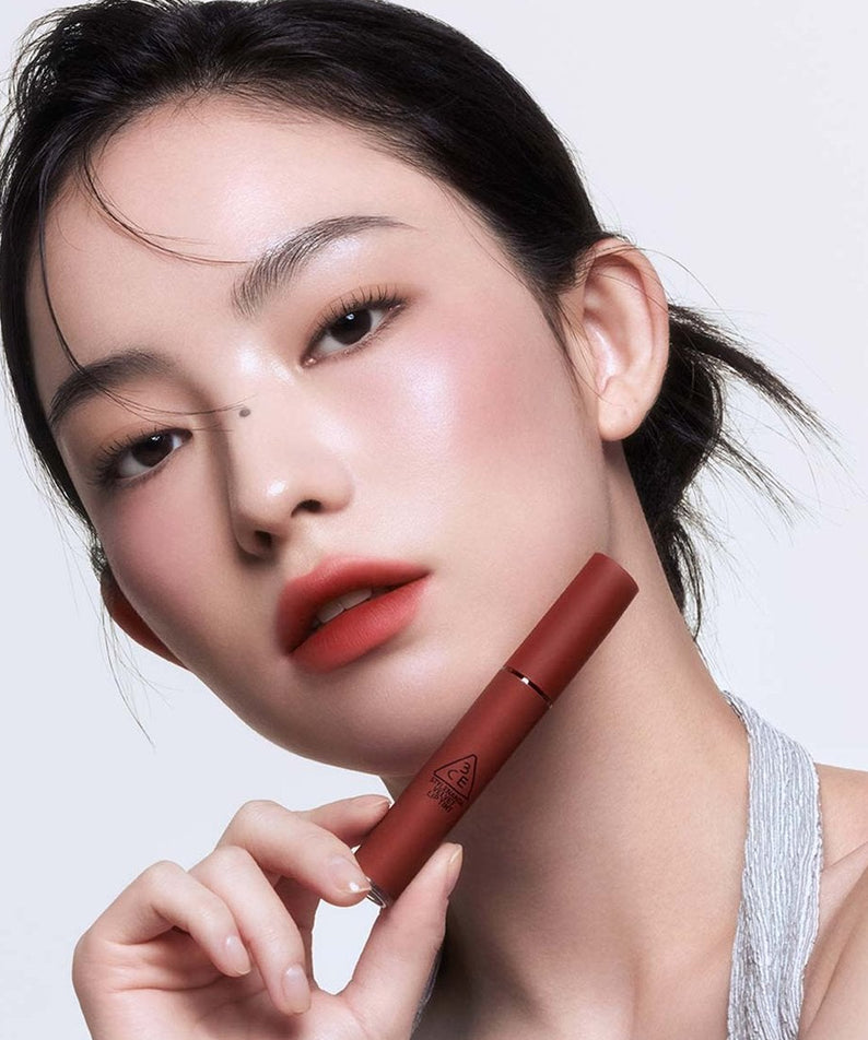 3CE Velvet Lip Tint sur une bouche maquillée, modèle en studio, teinte rouge veloutée de la marque 3CE.