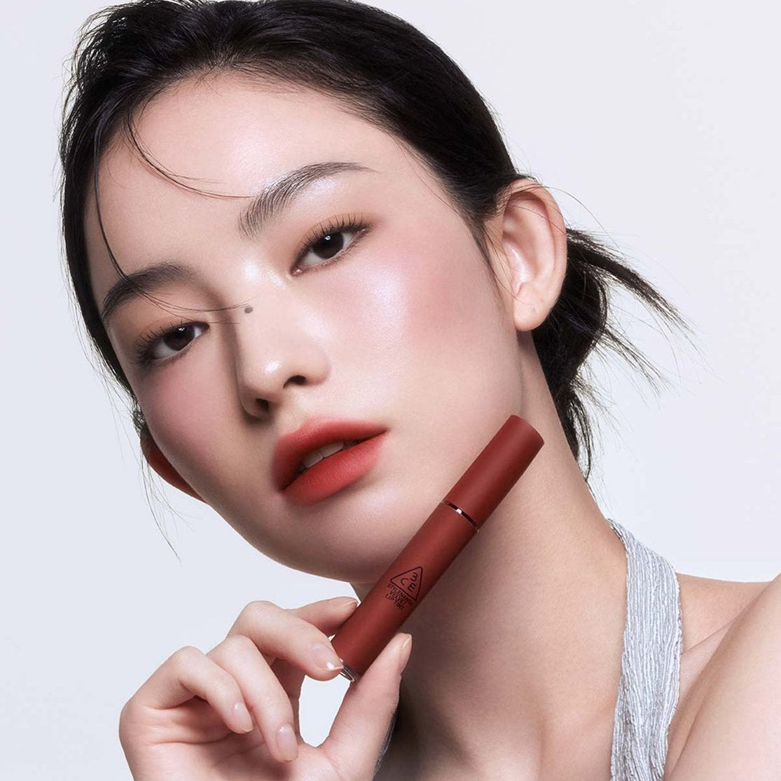 3CE Velvet Lip Tint sur une bouche maquillée, modèle en studio, teinte rouge veloutée de la marque 3CE.