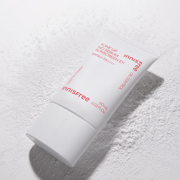 INNISFREE Tone Up No Sebum Sunscreen EX SPF 50+ PA++++ 60ml, tube blanc sur fond poudre, marque Innisfree visible.