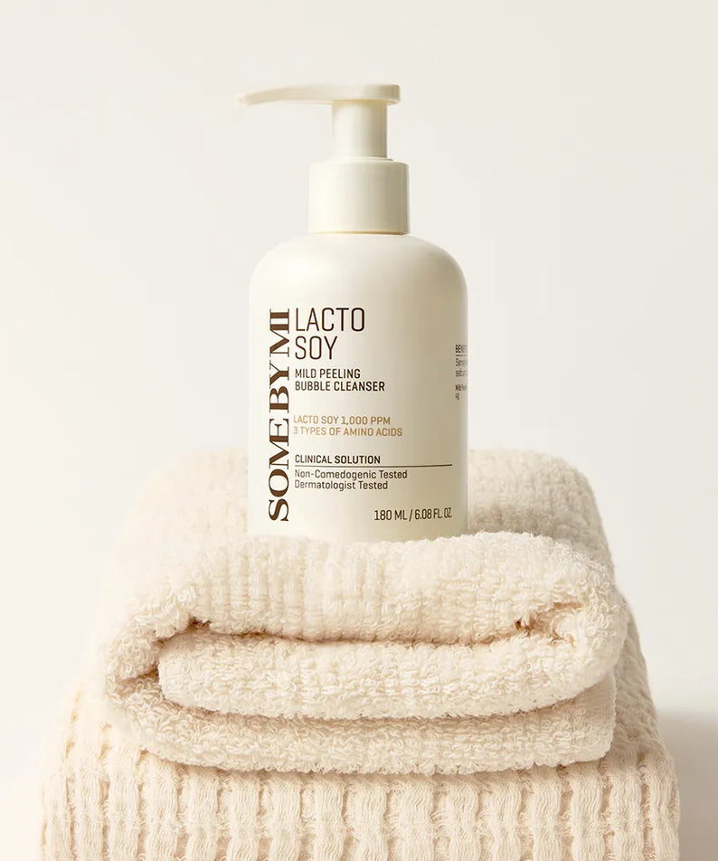 SOME BY MI Lacto Mild Peeling Bubble Cleanser 180ml, flacon blanc sur serviettes, style skincare minimaliste