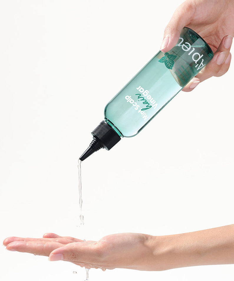 A'PIEU Mint Scalp Hair Vinegar 200ml : la main verse la solution aux huiles sur la peau, marque A'PIEU, fond clair.
