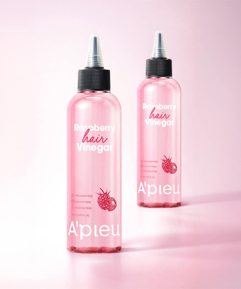 A'PIEU Raspberry Hair Vinegar 200ml de la marque A'PIEU, bouteilles roses sur fond rose, ambiance beauté capillaire.