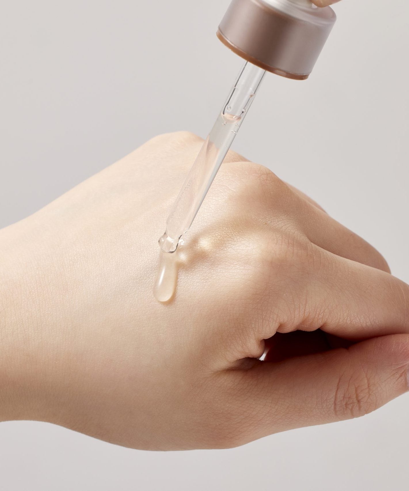 SKINFOOD Acorn Pore Peptide Ampoule 55ml, goutte d’ampoule sur main, marque SKINFOOD, contexte visuel beauté skincare.