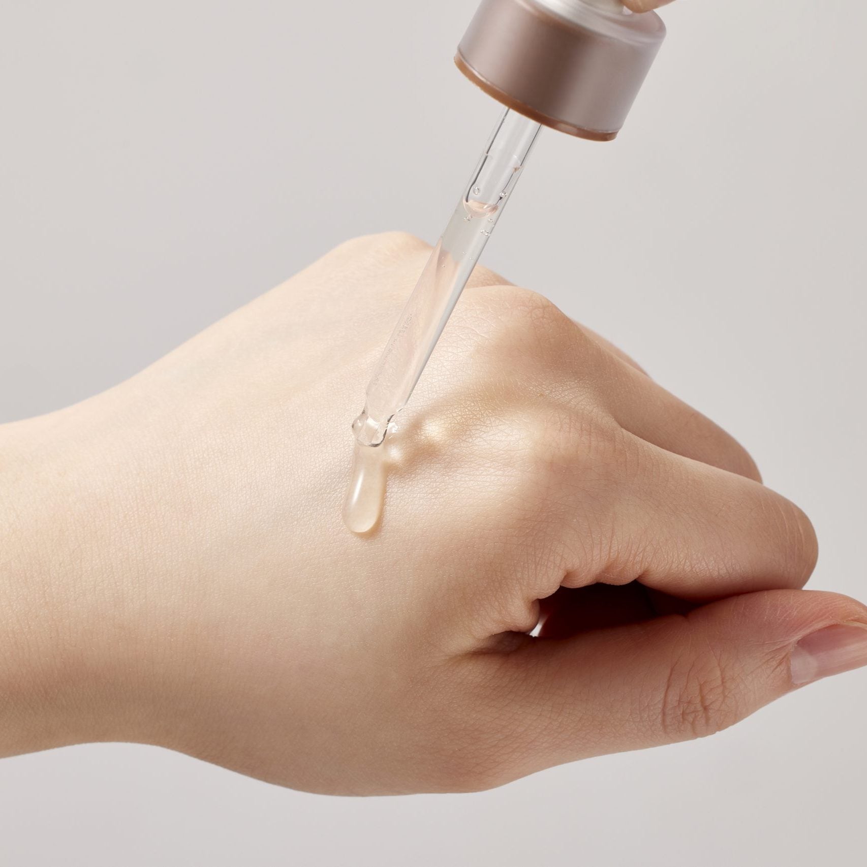 SKINFOOD Acorn Pore Peptide Ampoule 55ml, goutte d’ampoule sur main, marque SKINFOOD, contexte visuel beauté skincare.