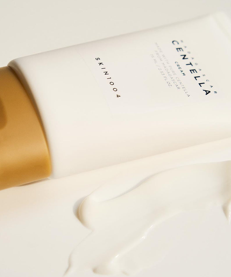SKIN1004 Madagascar Centella Cream 75ml en tube avec crème étalée, produit de soin hydratant et apaisant.