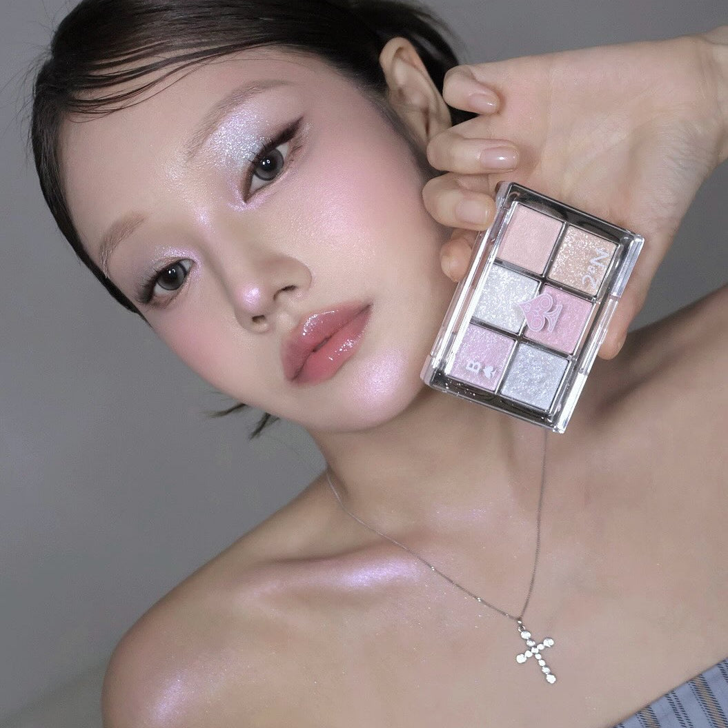 2AN  Better Me Eye Palette 4.5g, maquillage yeux sur modèle, palette ouverte avec fards rose et violets, fond gris.