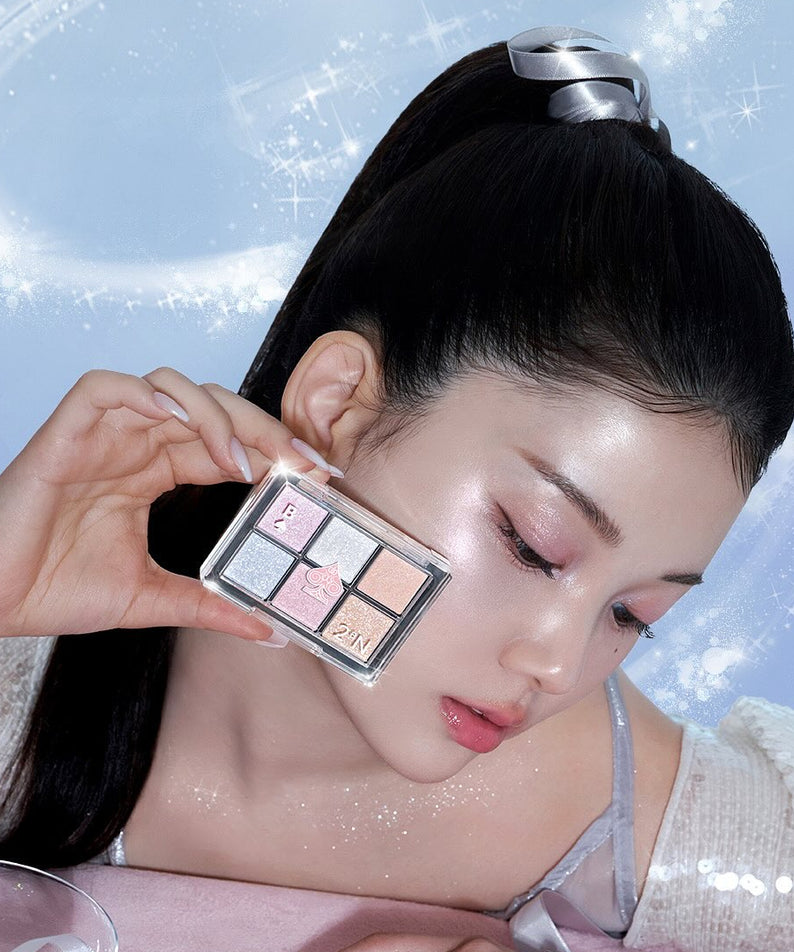 Photo produit 2AN  Better Me Eye Palette 4.5g : palette maquillage yeux tenue près du visage, marque 2AN, fond paillettes.