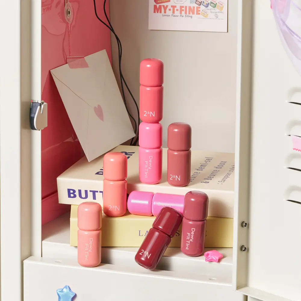 2AN Dewy Fit Tint 8 Colors, tubes de teinte dégradés roses sur étagère avec packaging, marque 2’N visible.