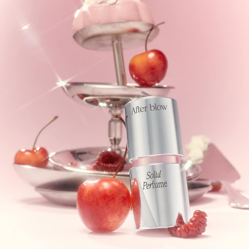 AFTER BLOW Solid Perfume 6.5g, stick solide en flacon sur fond rose, décor fruité avec marque After blow