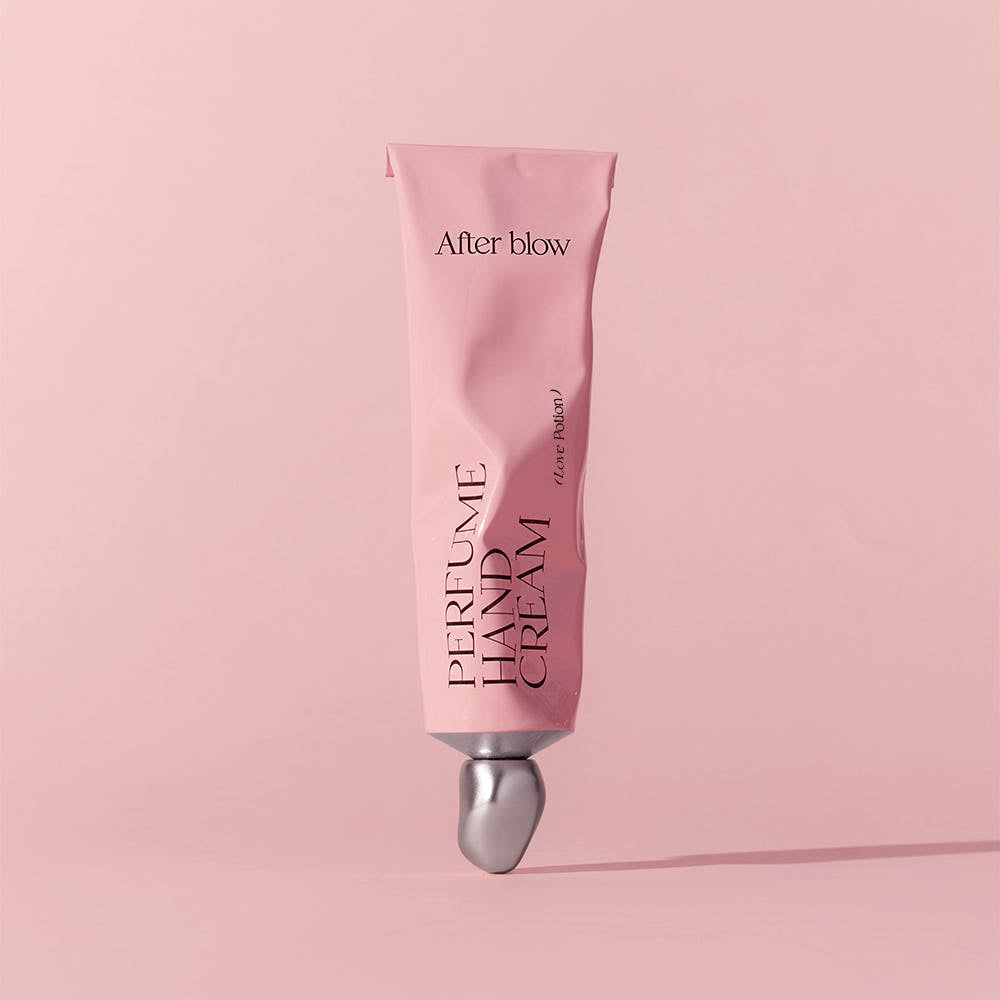 AFTER BLOW Perfume Hand Cream 50ml, tube rose After blow sur fond pastel rose, mise en scène beauté en douceur