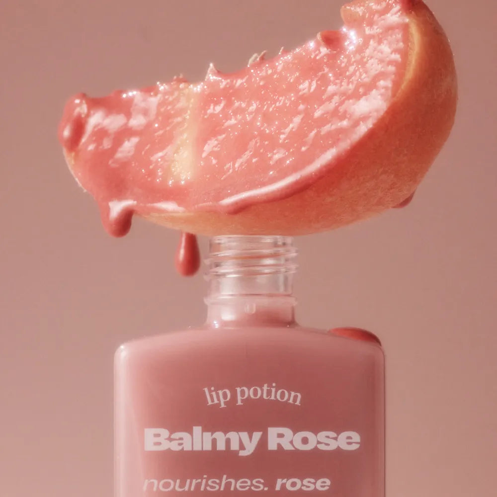 ALTERNATIVE STEREO Lip Potion Balmy Rose, texture rosée sur flacon maquillage, gros plan éclairage doux, style beauté.