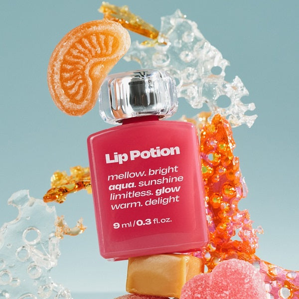 Décris l'image en français : ALTERNATIVE STEREO Lip Potion Aqua Glow Tint de la marque, flacon rose dans décor aqua.