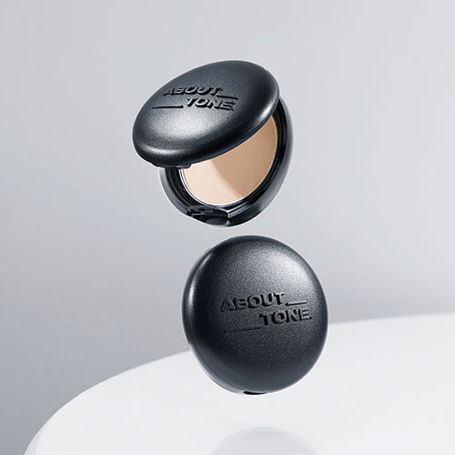 ABOUT TONE Blur Powder Pact, boîtier noir ouvert sur fond clair, teinte floue pour un effet mat, marque About Tone