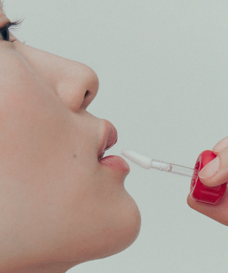 ALTERNATIVE STEREO Lip Potion Steaming Milk 9ml, la marque Alternative Stereo, application sur lèvres avec applicateur, fond clair.