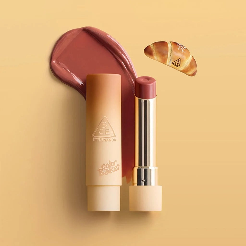 3CE Color Baker Glazy Lip Glow, baume à lèvres brillant bordeaux, produit de la marque 3CE sur fond beige