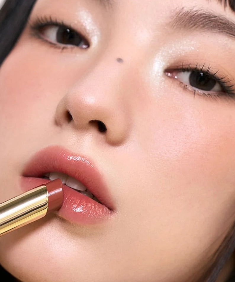 Vue rapprochée sur les lèvres avec 3CE Color Baker Glazy Lip Glow, teinte rosée brillante, maquillage 3CE sur fond studio.