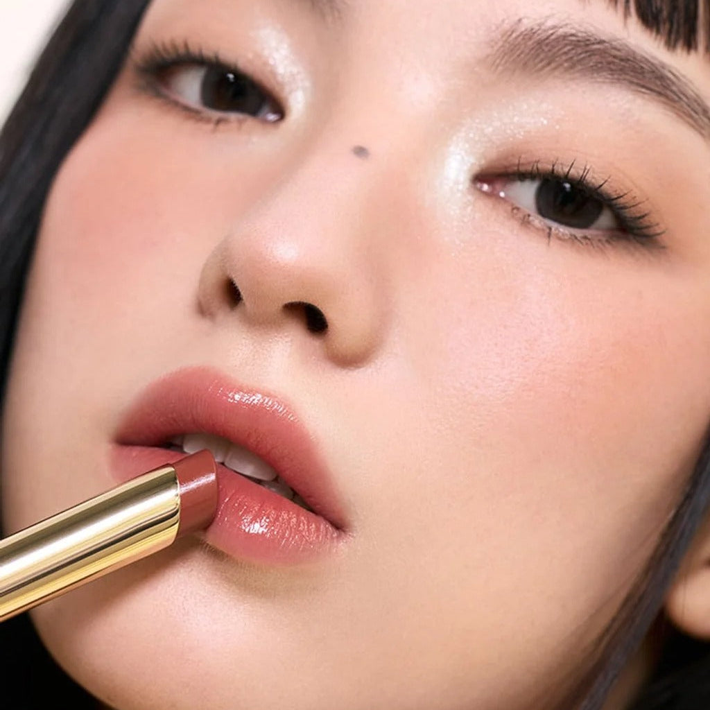 Vue rapprochée sur les lèvres avec 3CE Color Baker Glazy Lip Glow, teinte rosée brillante, maquillage 3CE sur fond studio.