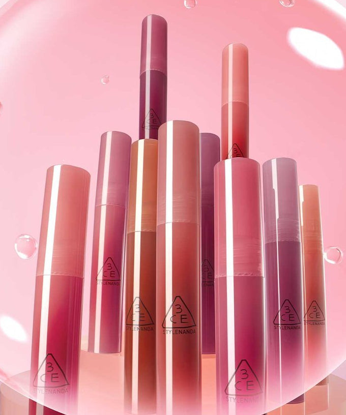 3CE Drop Glow Gel 10 Shades : tubes gloss couleur sur fond rose lumineux, gouttes et reflets, packshot beauté