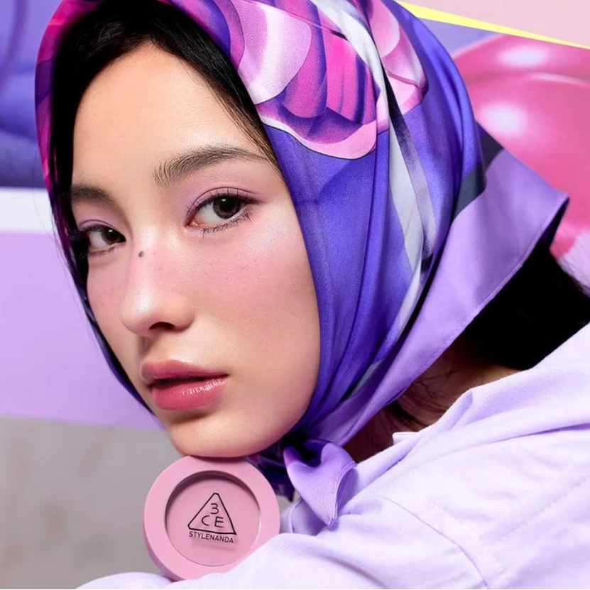 3CE Face Blush de 3CE sur maquillage: jeune femme au foulard violet, blush rose visible, intérieur lumineux